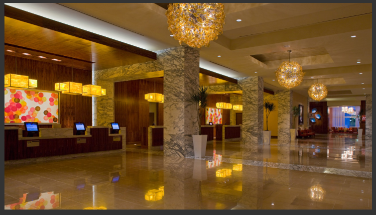 a lobby with marble columns and chandeliers