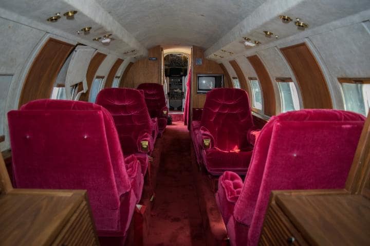 the inside of a plane with red seats