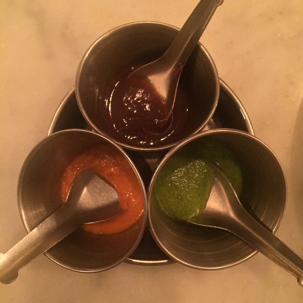 a group of metal cups with different sauces