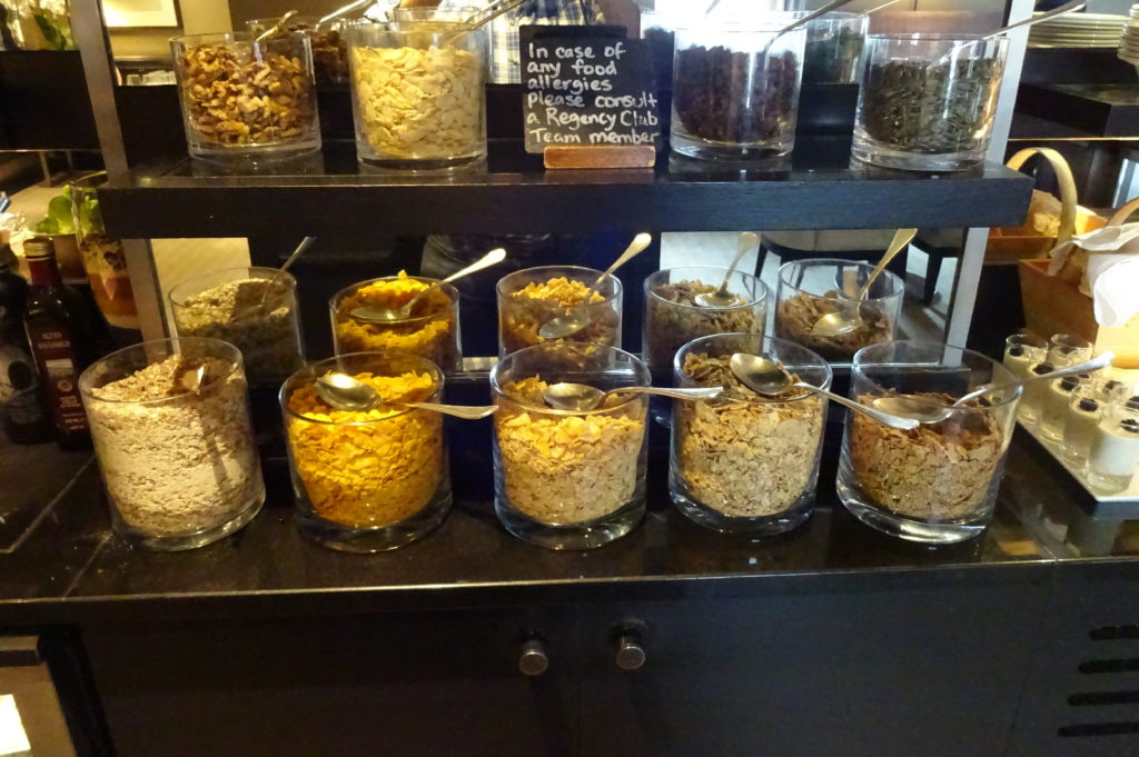 a shelf with different types of cereal and spoons