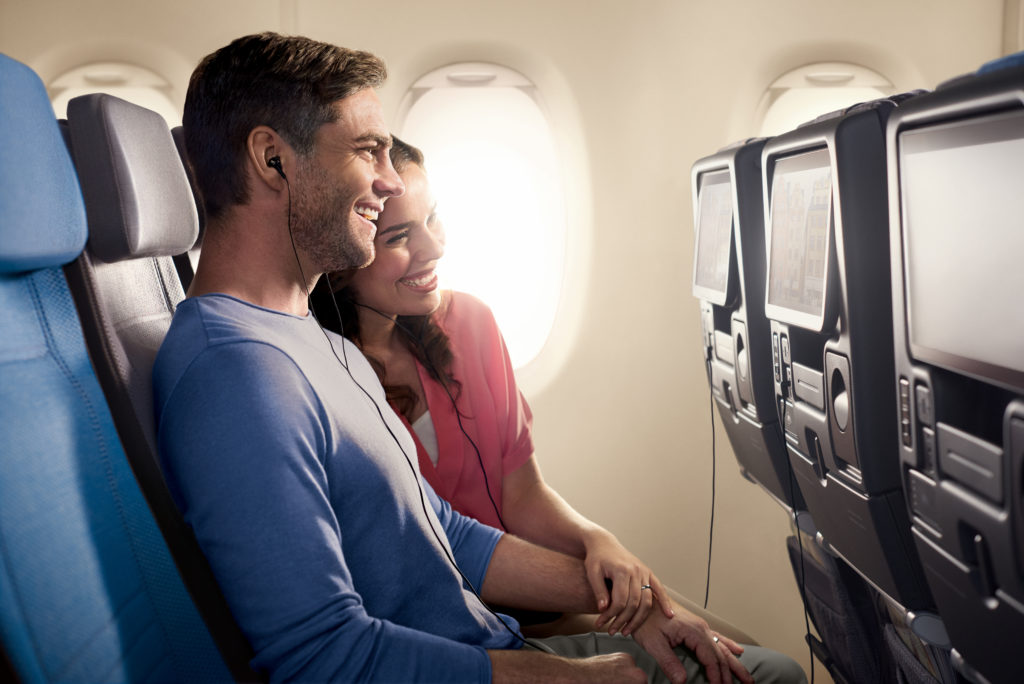 a man and woman sitting on an airplane