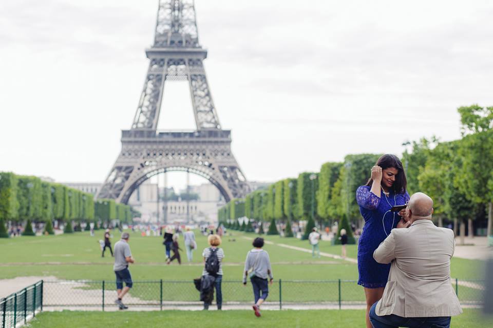 a man taking a picture of a woman in front of the eiffel tower