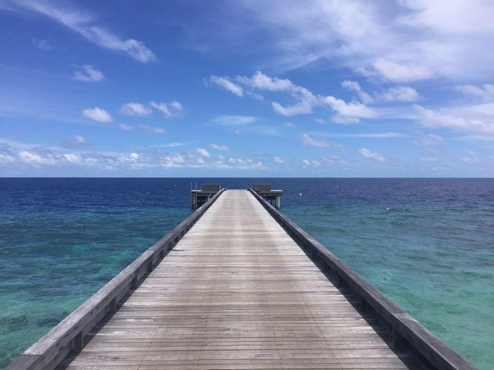 a wooden dock leading to the ocean