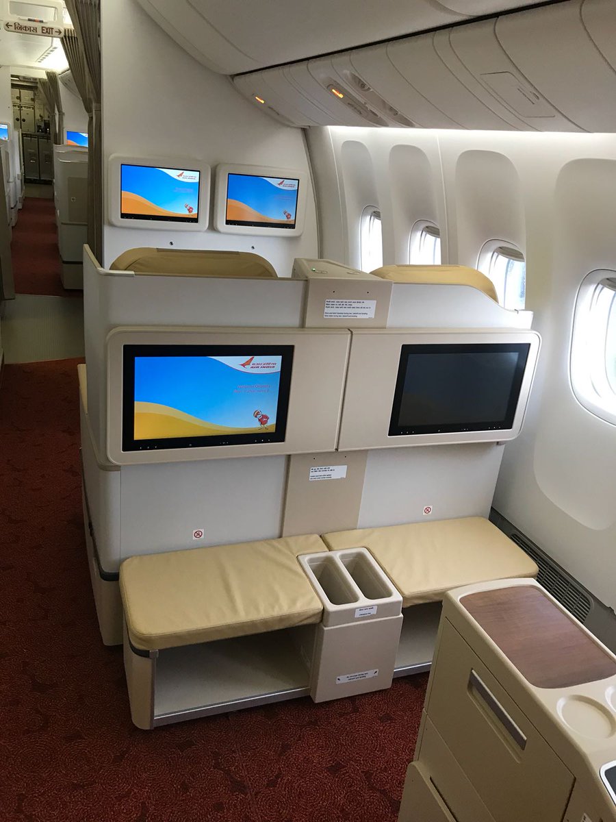 a seat and tv on the side of an airplane