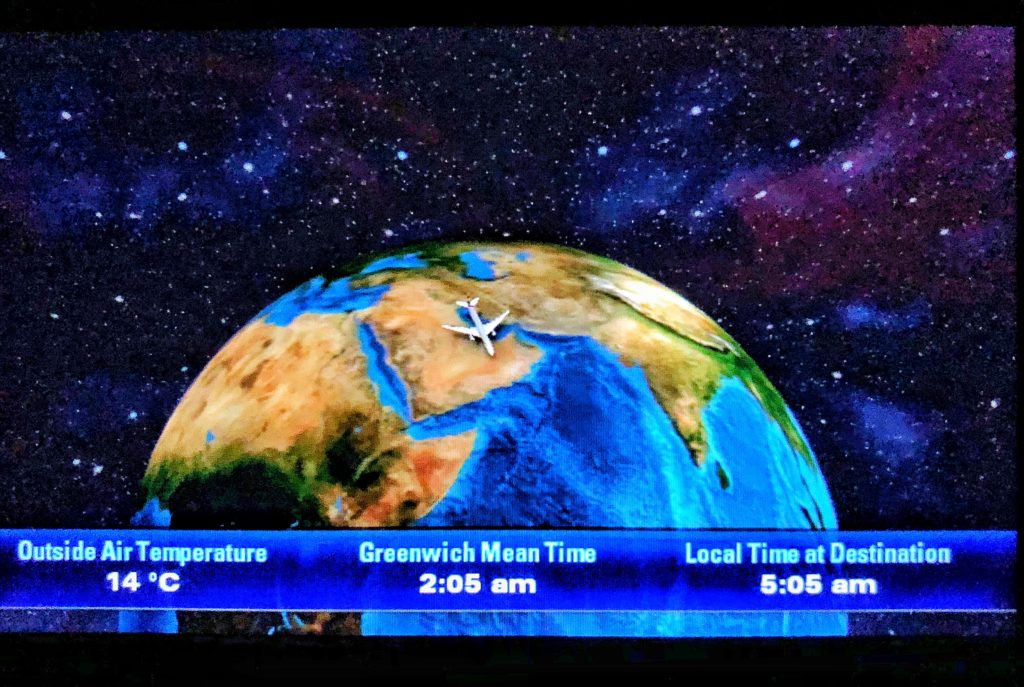 a screen shot of a television showing a plane flying over the earth