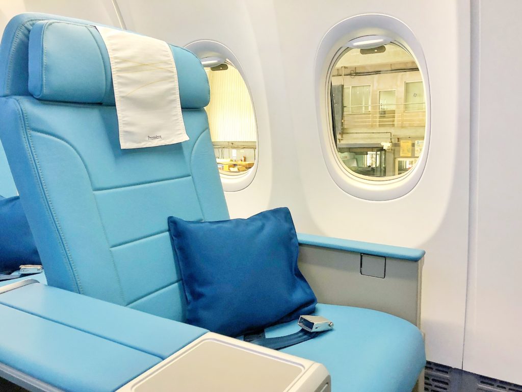 a blue seat with a pillow and a pillow in a plane