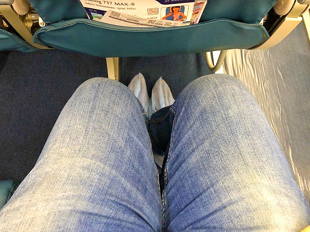 a person's legs in jeans and slippers