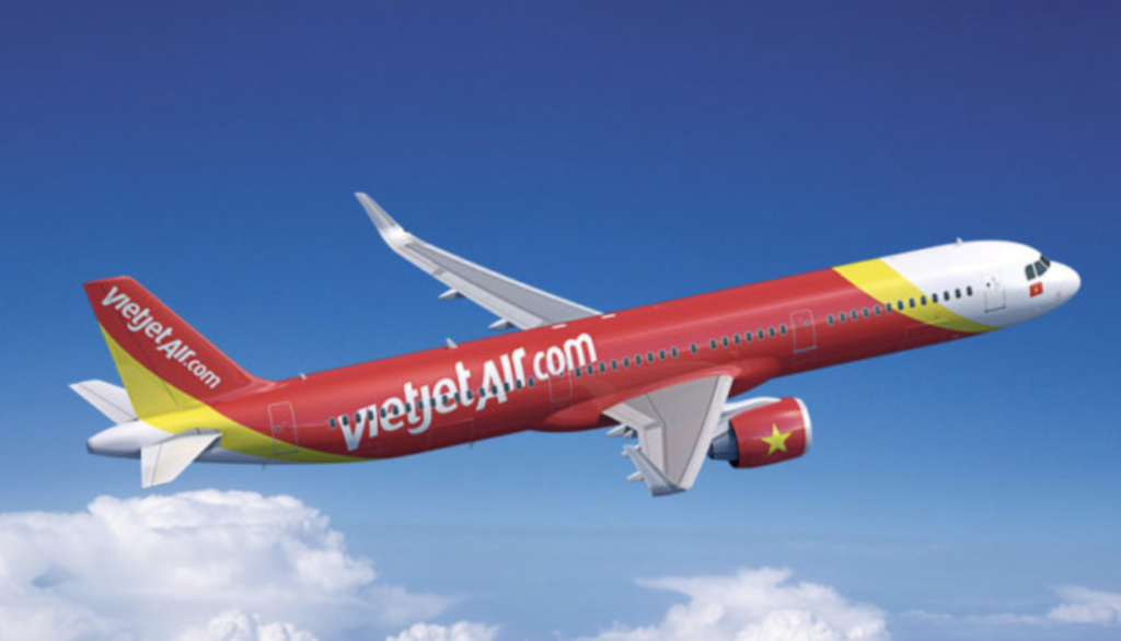 a red and yellow airplane flying in the sky