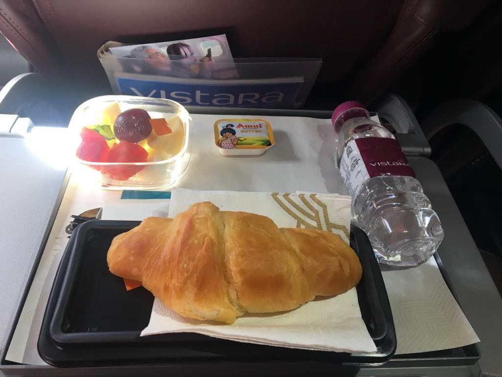 a croissant and fruit on a tray