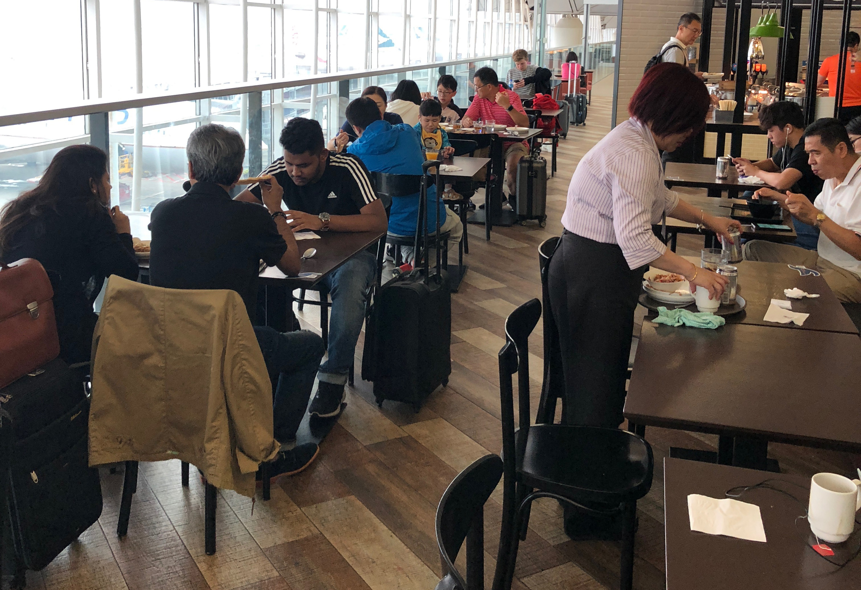a group of people sitting at tables in a cafeteria