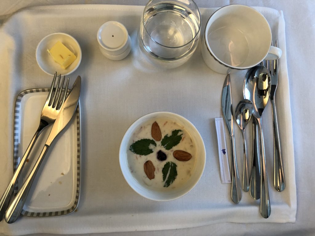 a table with a bowl of food and silverware