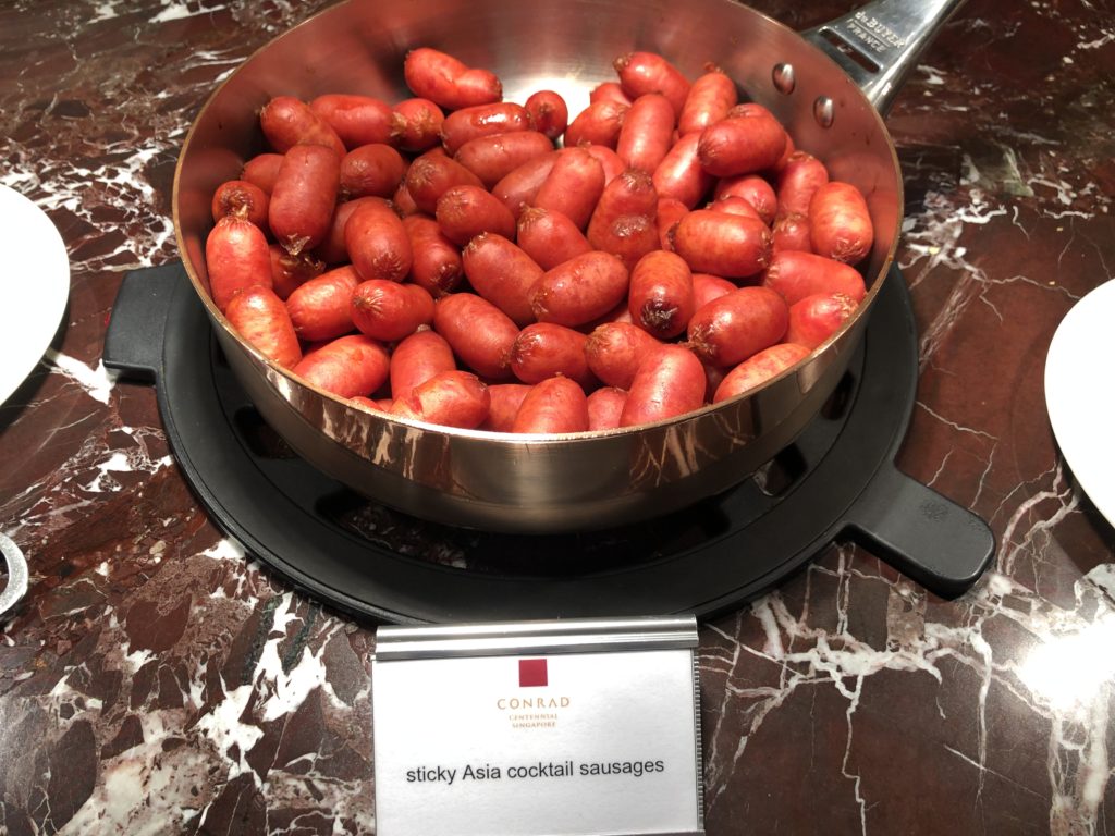 a pan of sausages on a marble surface