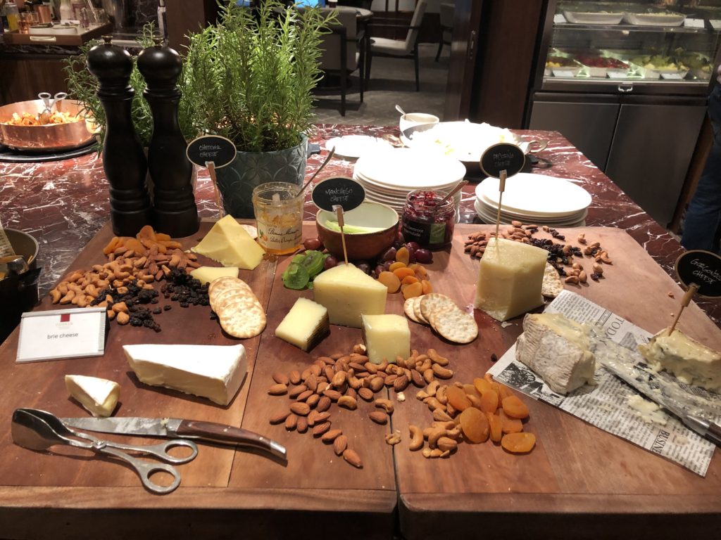 a table with different types of cheese and nuts