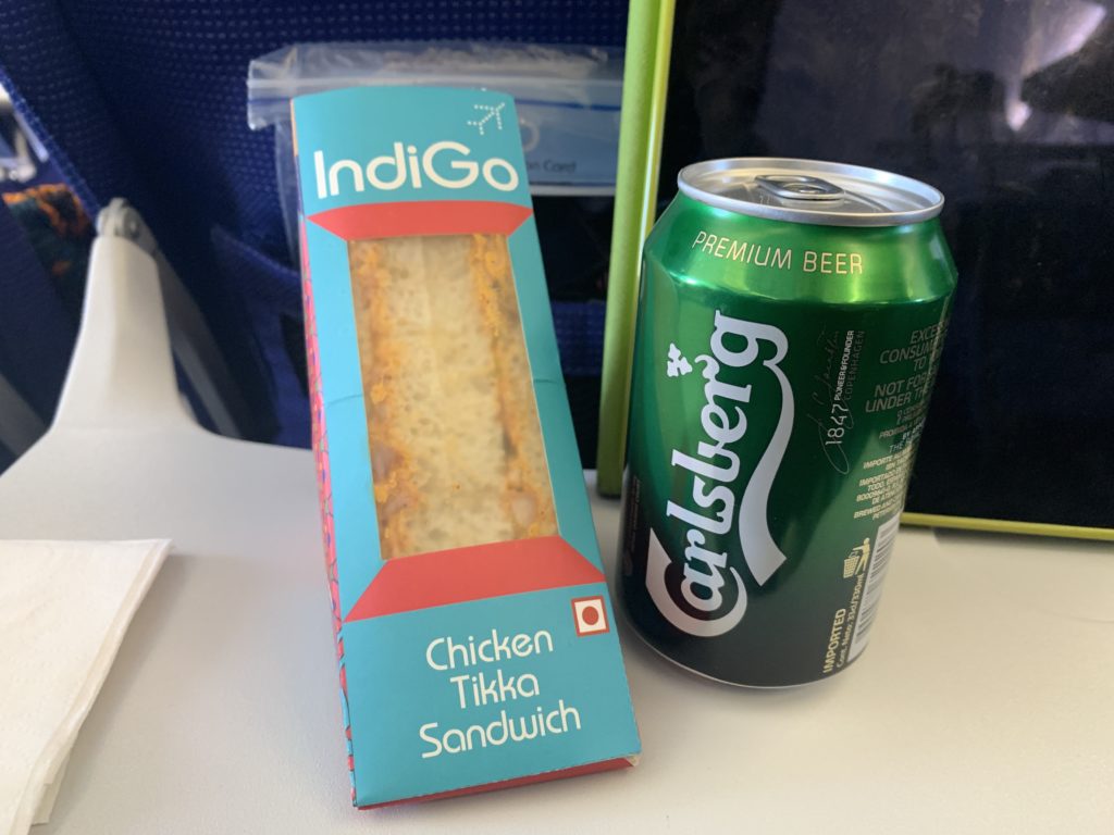a can of beer next to a sandwich