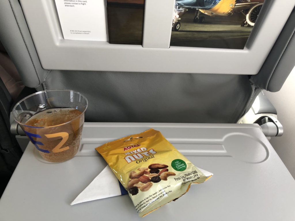 a plastic cup and a bag of nuts on a tray