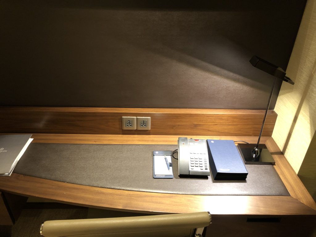 a desk with a phone and a phone and a pen