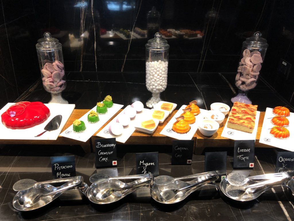 a table with different desserts and spoons
