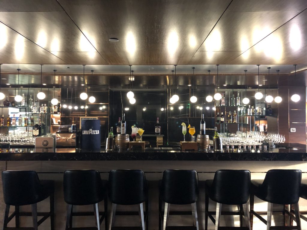 a bar with chairs and a row of lights