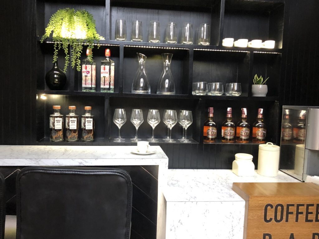 a black shelf with glasses and bottles on it