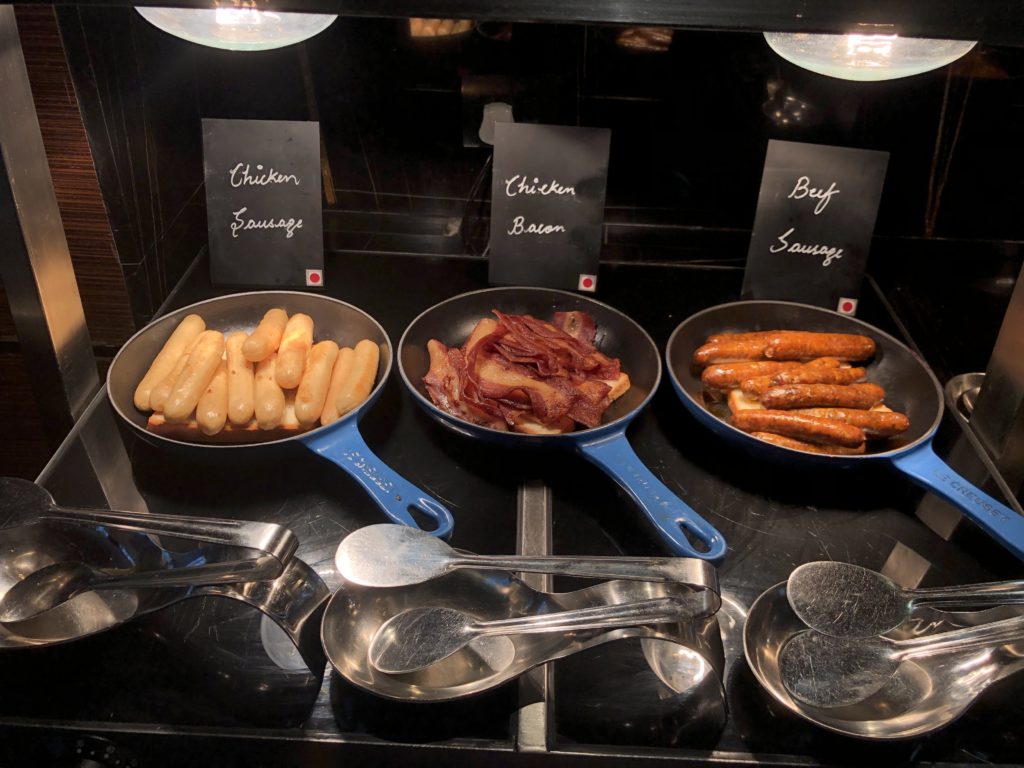 a group of pans with different types of sausages and bacon