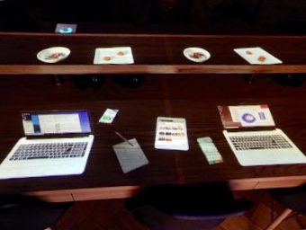 a table with several laptops and papers on it