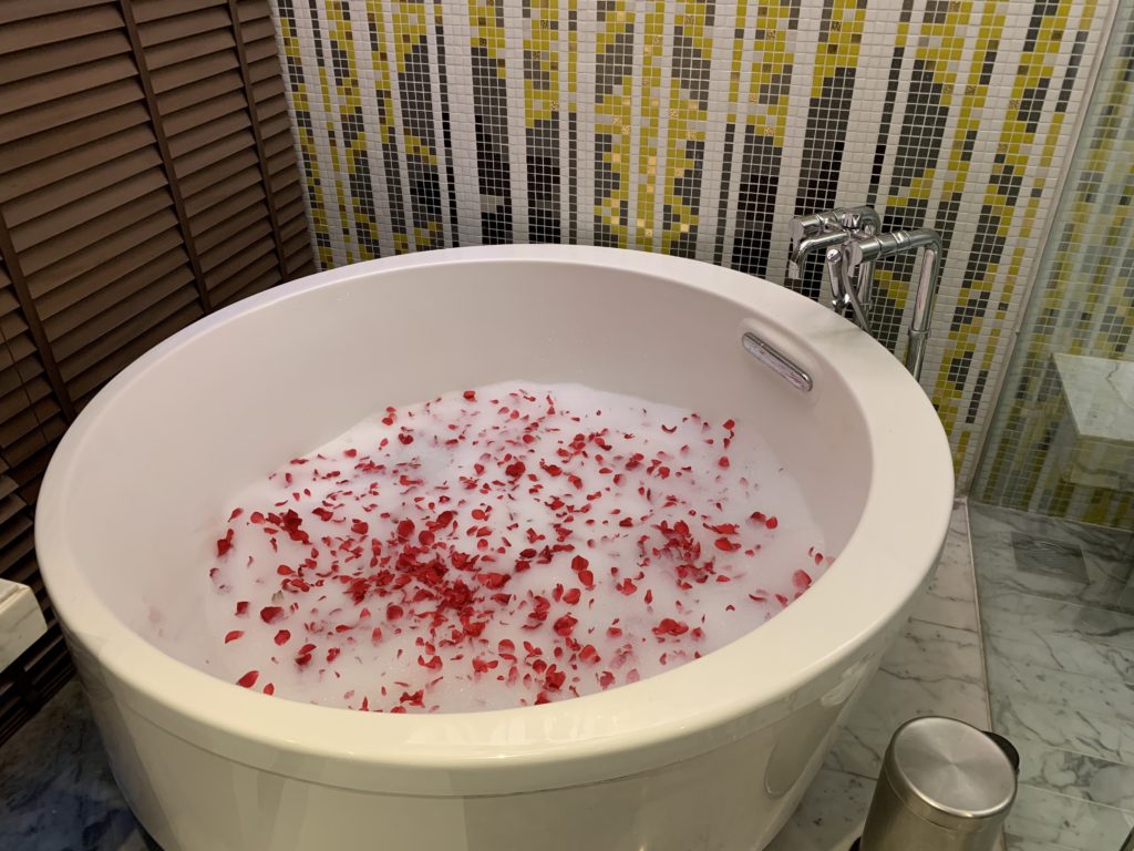 a bath tub filled with water and red petals
