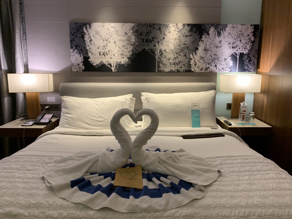 a bed with two swans made of towels