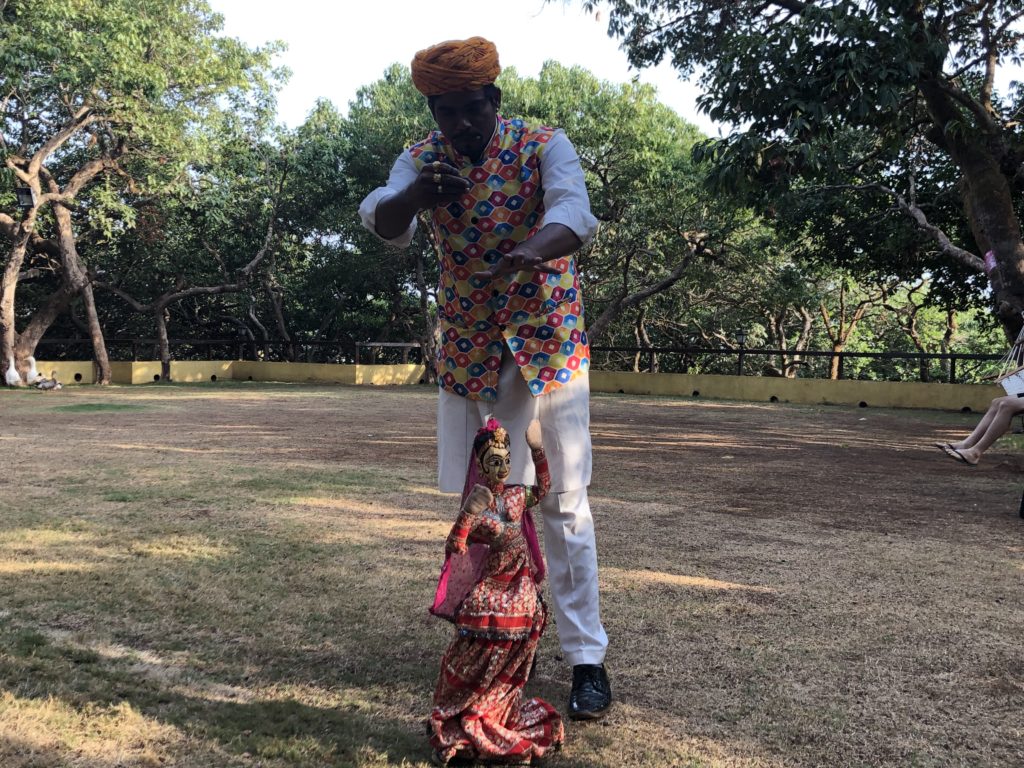 a man in a turban pointing at a doll