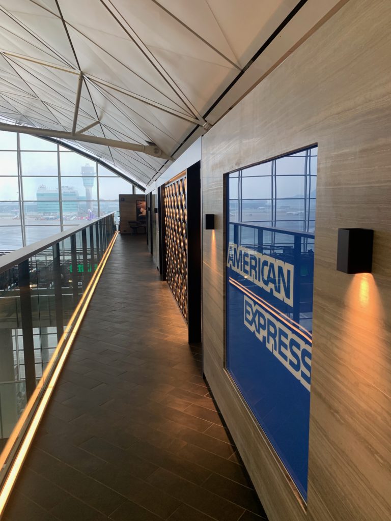 a hallway with a glass wall and a sign