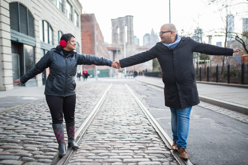 a man and woman holding hands on a street
