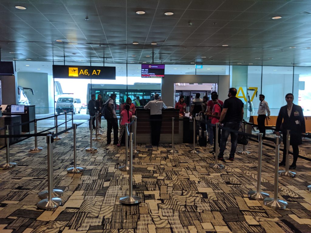 people standing in a line at a counter in a airport