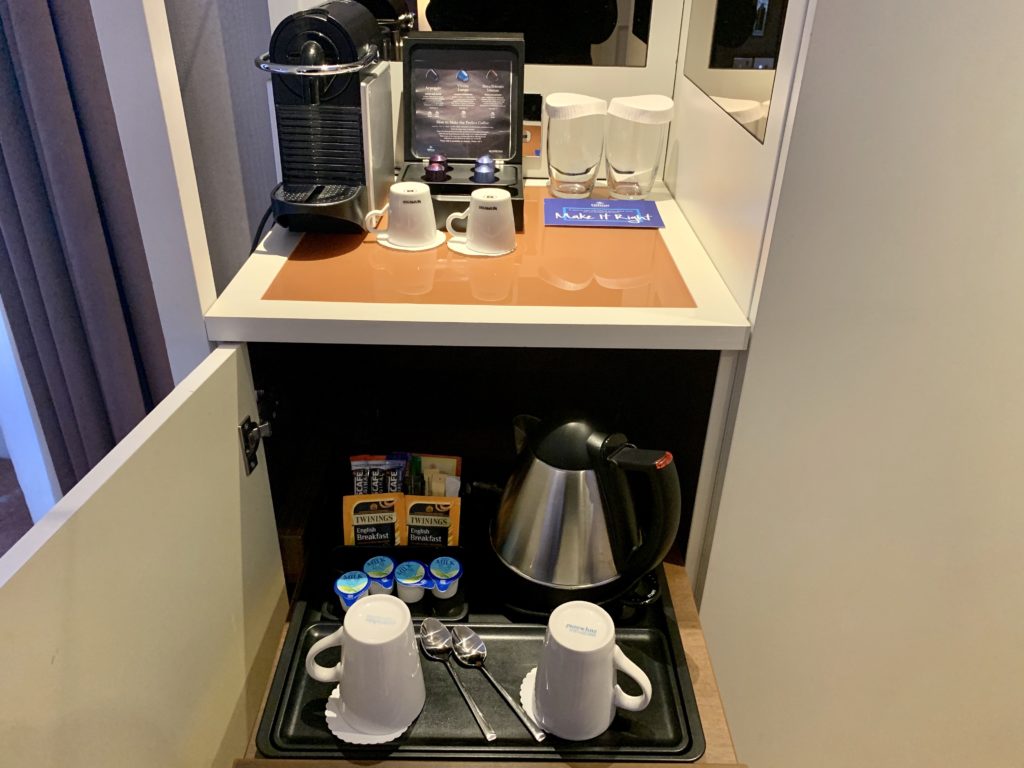 a coffee machine and cups on a shelf