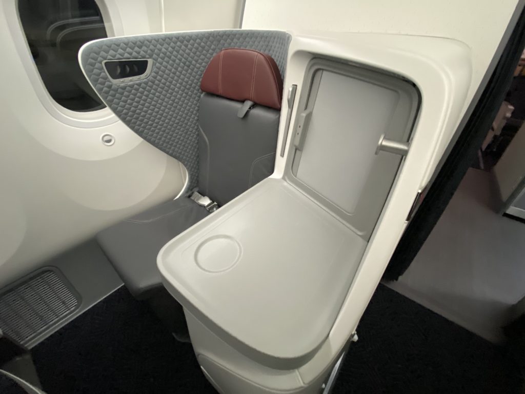 an airplane seat with a door open